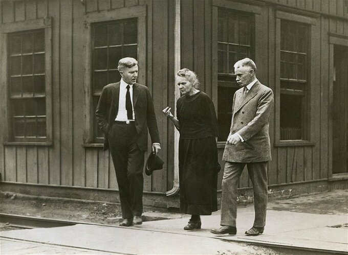 marie-curie-caminando-junto-a-otros-dos-cientificos-en-la-planta-de-refineria-de-radio-en-pittsburgh-en-1921_da7c1512_800x588
